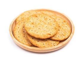 Baked round cracker chips in wooden dish isolated on white background. Wheat cracker chips isolated on white background. Whole wheat cracker isolated on white background with clipping path photo
