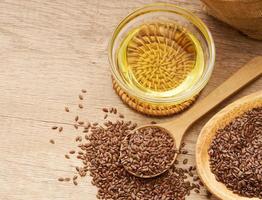 flaxseed linseed and oil in wood bowl on wooden table background. flaxseed linseed oil and bag. flaxseed linseed oil photo