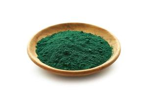 spirulina powder in wood plate isolated on white background. green spirulina powder in a wooden dish isolated on white background. spirulina or seaweed powder isolated on white background photo