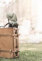 vintage camera on old baggage bag on grass photo