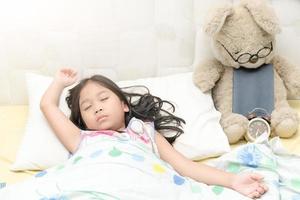 linda niña dormir dulce sueño con osito de peluche oso foto