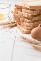 slice bread with ingredients for making bread on with wood background photo