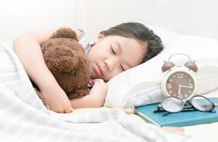 linda pequeño asiático niña dormir en cama foto