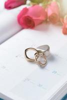 Wedding gold rings locked with lock on calender photo