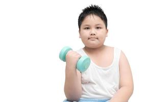 obese fat boy is doing exercises with dumbbells photo