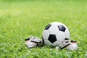 football on green grass and stud shoe photo