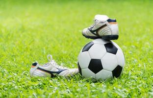 football on green grass and stud shoe photo