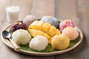 ripe mango with sticky rice on wood background photo