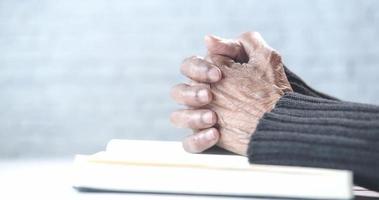 ouderen vrouw zetten haar handen Aan een boek en bidden video