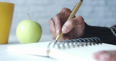 Close up of senior woman hand writing on notepad video