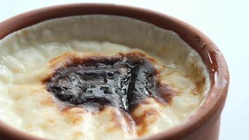 rice Caramel pudding in a glass jar on table . video