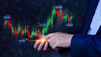 Hand of businessman or trader is showing growing virtual hologram stock on smartphone, planning and strategy, Stock market, Business growth, progress or success concept. invest in trading. photo