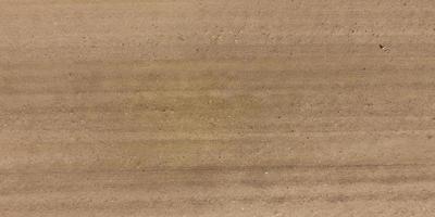 panorama of surface from above of gravel road with car tire tracks photo