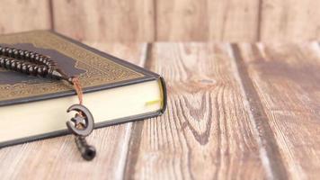 Holy book Quran and rosary on table, close up video