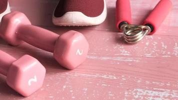 Top view of dumbbell, shoe on pink background video