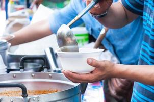 hand  holding Spoon food in the foam tray ,streetfood photo