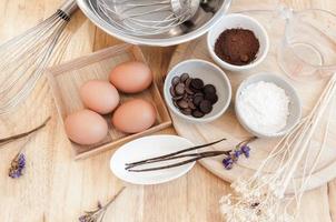 vista superior preparación para hornear en mesa de madera,ingredientes para hornear. tazón, huevos y harina, rodillo y cáscaras de huevo en tablero de madera, concepto de horneado foto