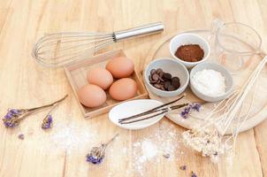 vista superior preparación para hornear en mesa de madera,ingredientes para hornear. tazón, huevos y harina, rodillo y cáscaras de huevo en tablero de madera, concepto de horneado foto