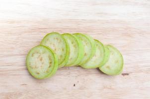 resh green eggplant sliced on wooden board photo