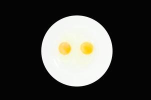 Raw egg yolks in a white bowl isolated on a black background, To prepare for a high protein diet has helped in the growth of a person's body photo