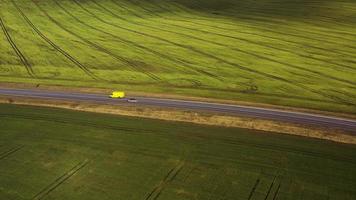 Top view of a cars driving along a rural road between two fields video