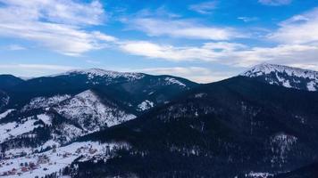 hyper upphöra av moln löpning på blå himmel över Fantastisk landskap av snöig bergen och barr- skog på de sluttningar video