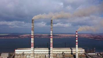 aéreo Visão do velho termoelétrica plantar com grande chaminés dentro uma rural panorama perto a reservatório video