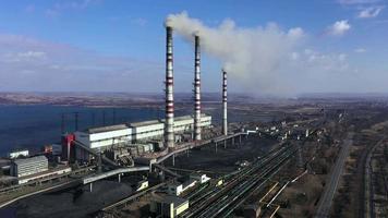 Aerial view of old thermoelectric plant with big chimneys in a rural landscape near the reservoir video