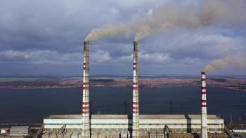 aéreo ver de antiguo termoeléctrico planta con grande chimeneas en un rural paisaje cerca el reservorio video