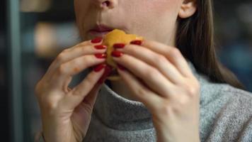 vrouw eet een Hamburger in een cafe video