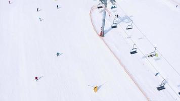 Aerial hyperlapse of ski slope - ski lift, skiers and snowboarders going down video