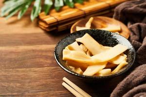 Ajitsuke Menma Pickled Bamboo Shoot in a wood dish on wooden table background with copy space photo