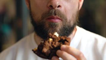 hombre come un chocolate chip galletas en un café video