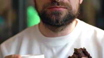 Man eats a chocolate chip cookies in a cafe video