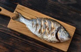 Grilled fish on the wooden board photo
