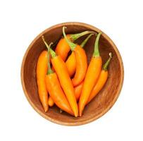 orange chili pepper in wood bowl isolated on a white background. orange chili pepper isolated. Orange Cayenne Pepper photo