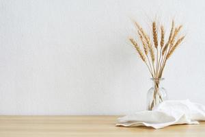 Blank mockup on a white wall with barley wheat on the glasses vase. View of modern style interior with artwork mock up on wall. Home minimalism background photo