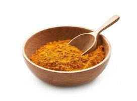 a pile of ground turmeric powder or curcumin powder in wood plate and scoop isolated on white background. turmeric or curcumin powder isolated photo