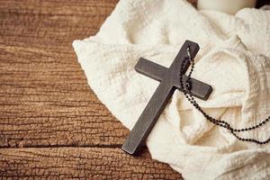 Concept of Christian. close up Jesus Christ black cross on the old wooden table background with copy space photo