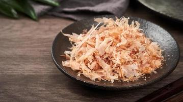 close up Bonito Flakes or katsuobushi on a ceramic plate on a cement background photo