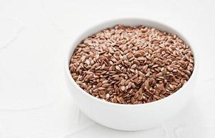 Flaxseed linseed in bowl on white table background. Flaxseed linseed heap on white background. Pile of Flaxseed linseed in bowl on white background. flax seed photo