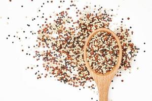 top view or flat lay quinoa seeds in wooden spoon isolated on white background. close up quinoa seeds in wooden spoon isolated on white background. quinoa seeds in spoon isolated photo
