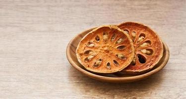 dry Indian bael fruit in wood plate on wooden table kitchen background. Indian bael fruit in wood plate. group of Indian bael fruit background photo