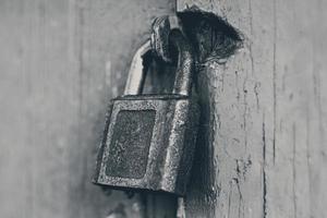 old iron padlock on locked closed door photo