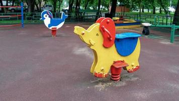 play ground in summer park, empty swing and rocking horse photo