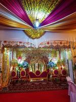 Typical Minang wedding decorations, bridal chairs and carpets are red with other flashy yellow decorations. photo