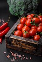 Fresh red cherry tomatoes in a wooden vintage box photo