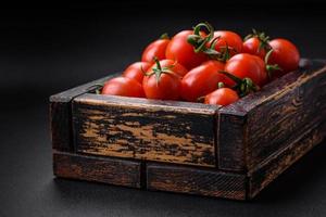 Fresh red cherry tomatoes in a wooden vintage box photo