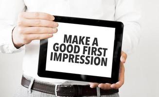 Businessman hold black tablet with text Make a good first impression photo