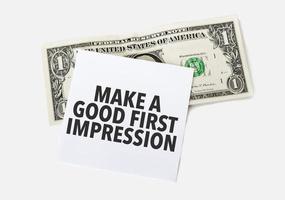 1 dollar bill and white notepad sheet on the white background. Text Make a good first impression. photo